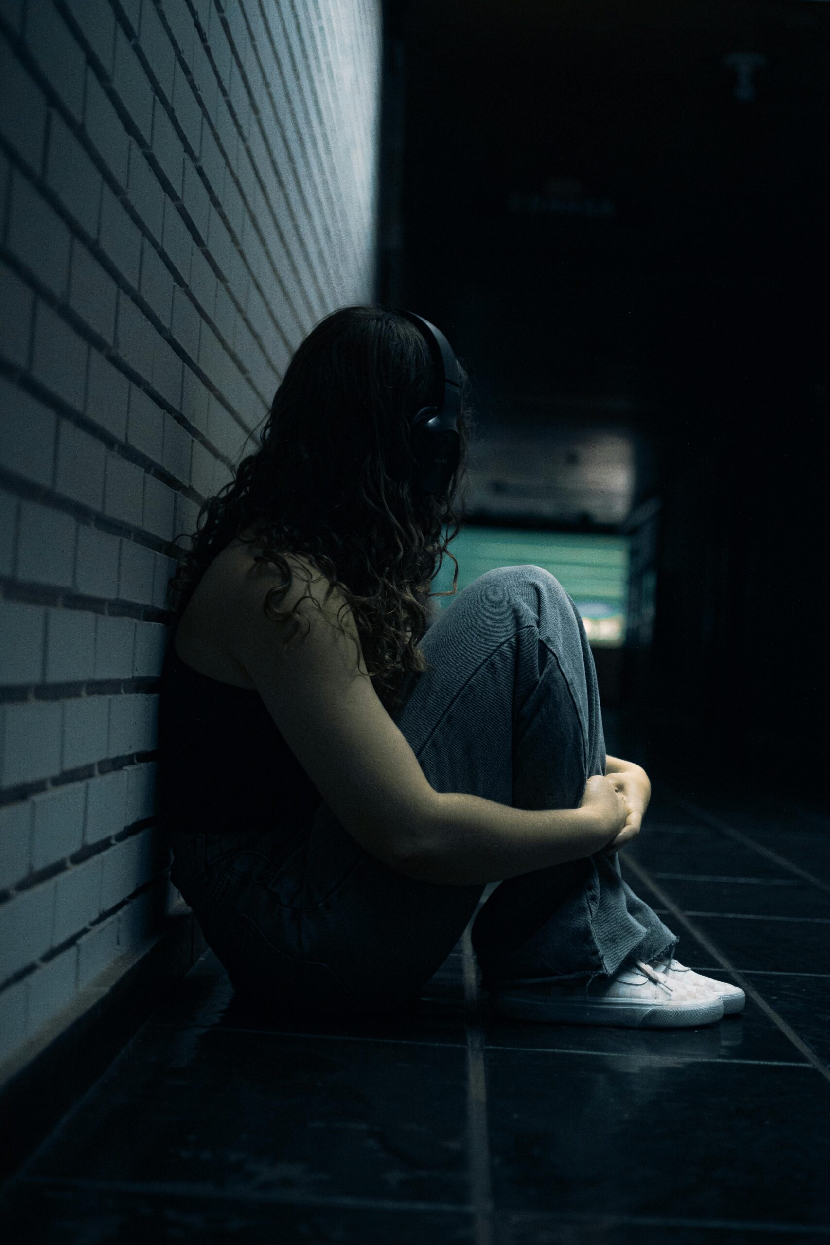 Female sitting down in dark setting.